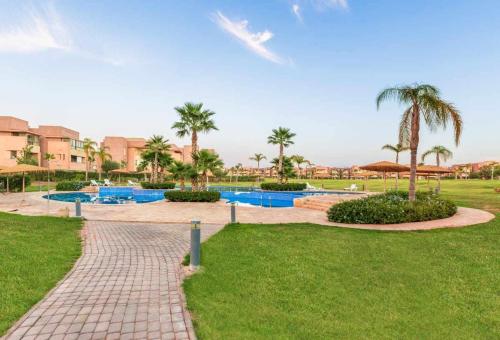 a resort with a swimming pool and palm trees at Prestigia golf city porte agate in Marrakech