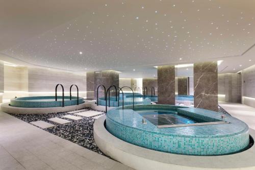 a hotel lobby with three jacuzzi pools at Hilton Xi'an High-tech Zone in Xi'an