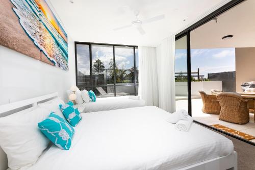 two beds in a bedroom with a large window at Solaris 310 in Forster