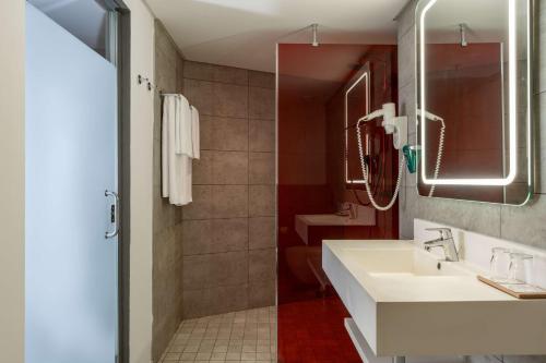 a bathroom with a sink and a shower at Park Inn by Radisson Libreville in Libreville