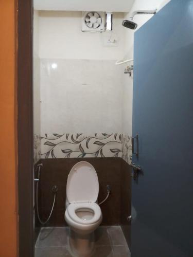 a small bathroom with a toilet in a stall at The Nisarga Residency in Bengaluru