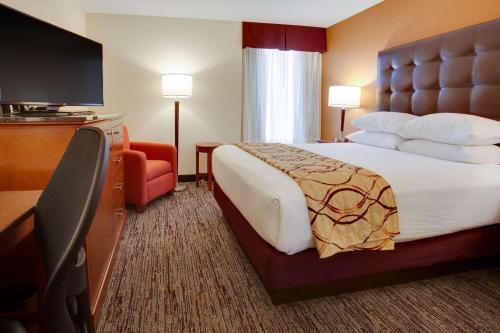 a hotel room with a bed and a flat screen tv at Drury Inn & Suites Terre Haute in Terre Haute