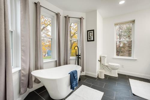 a white bathroom with a tub and a toilet at Family-Friendly Hatfield Home 3 Mi to Downtown! in Hatfield