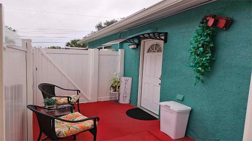 una casa verde con suelo rojo y puerta blanca en Green Castle Apartment in Tampa Near Airport and Busch Gardens, en Tampa