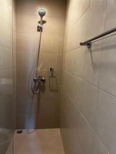 a shower with a shower head in a bathroom at 1 Bedroom Condo unit across Iloilo Convention Center in Iloilo City