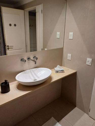 uma casa de banho com um lavatório branco e um espelho. em Estudio VIP en Recoleta em Buenos Aires