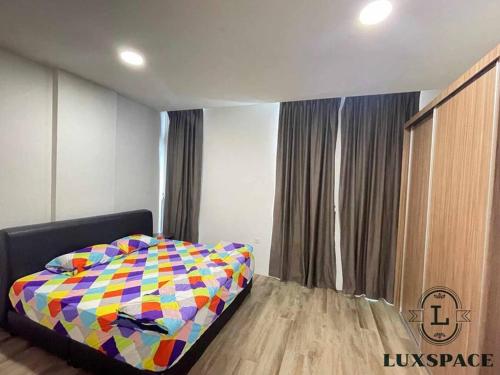a bedroom with a colorful bed in front of a window at Kuching City 3rd Mile Batu Kawa Cozy Apartment in Kuching