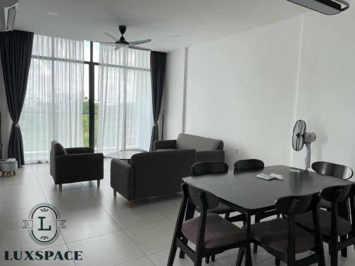 a living room with a dining room table and chairs at Kuching City 3rd Mile Batu Kawa Cozy Apartment in Kuching