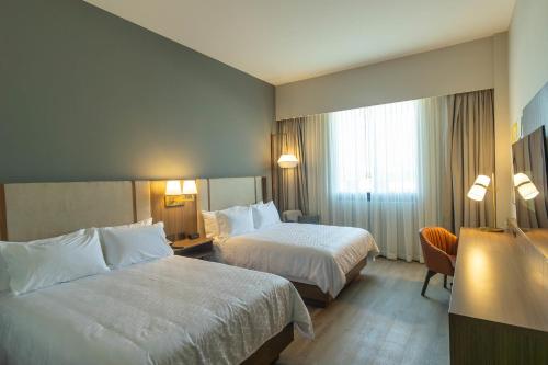 a hotel room with two beds and a window at Holiday Inn Navojoa by IHG in Navojoa