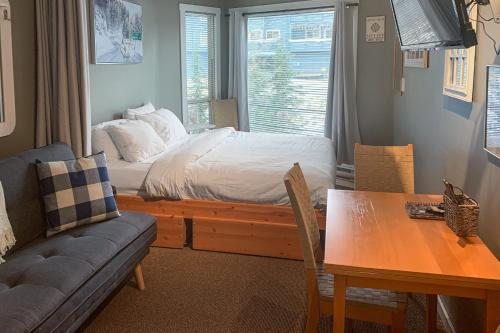 sypialnia z łóżkiem, stołem i kanapą w obiekcie The Lepard's Den - Whitefoot Lodge 206 w mieście Big White