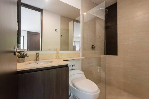 a bathroom with a toilet and a sink and a mirror at Hermoso loft en Llanogrande in Rionegro