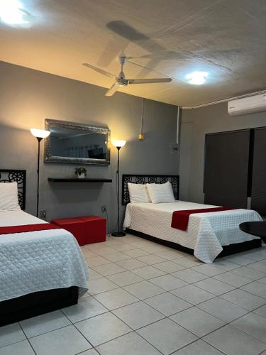 - une chambre avec 2 lits et un ventilateur de plafond dans l'établissement Preciados Loft Cold AC best WIFI, à Tequila