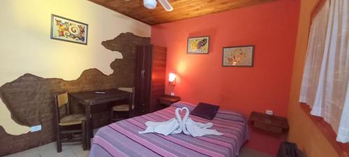 um quarto com uma cama com duas toalhas brancas em Hostería El Gusto Es Nuestro em Capilla del Monte