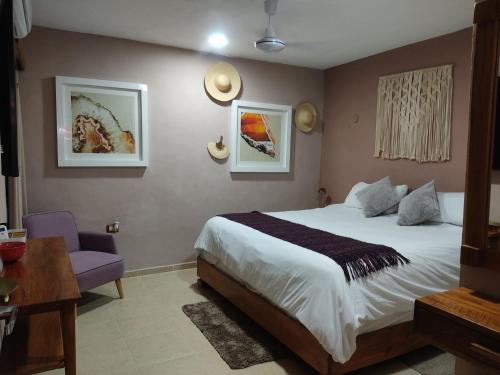 een slaapkamer met een groot bed en een paarse stoel bij Casa Mercedes in Valladolid
