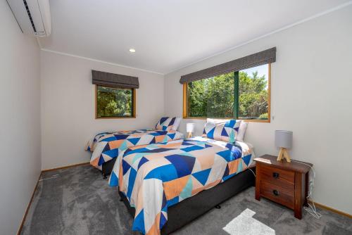 - une chambre avec 2 lits et une fenêtre dans l'établissement Central Wanaka Home, à Wanaka