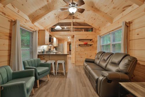 a living room with a couch and chairs and a kitchen at Stefan Cabin Nature-nested Tiny Home Hot Tub in Chattanooga