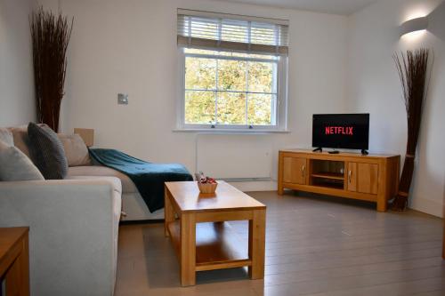 a living room with a couch and a tv at Business Stays in Reading with FREE Parking in Reading