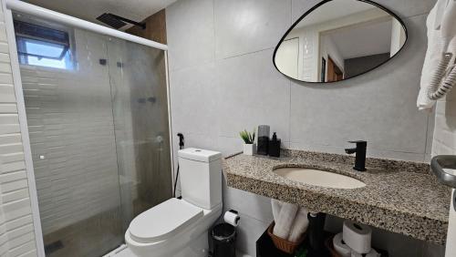 La salle de bains est pourvue de toilettes, d'un lavabo et d'un miroir. dans l'établissement O melhor studio em São Luís, à São Luís