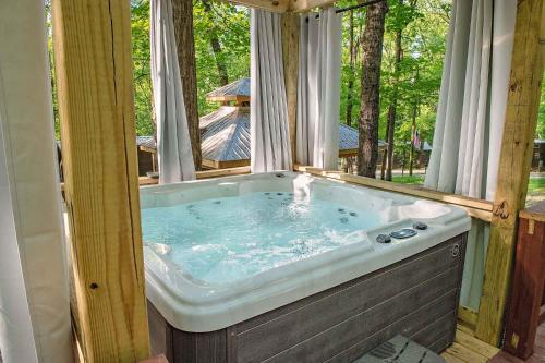 une baignoire jacuzzi dans une maison avec fenêtre dans l'établissement Stefan Cabin Nature-nested Tiny Home Hot Tub, à Chattanooga