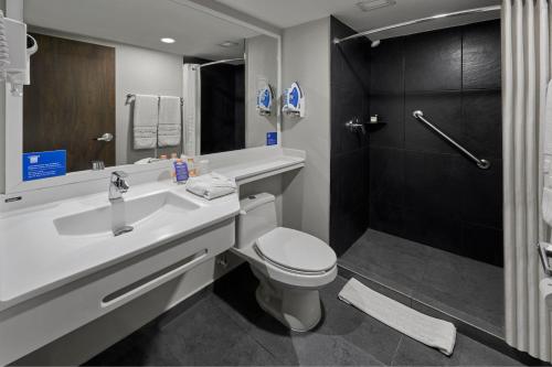 a bathroom with a sink and a toilet and a shower at City Express by Marriott Queretaro in Querétaro