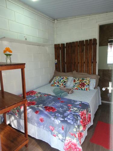 a bedroom with a bed with a blue comforter at Pé na Areia Sons do Mar in Guarujá