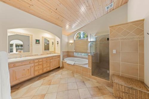 a bathroom with a tub and a shower and a sink at Fox Crossing at Tahoe Donner Vacation Rental w Forested Views in a Prime Location in Truckee
