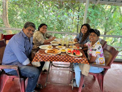 a group of people sitting at a table eating food at Marari Beach Villas in Mararikulam