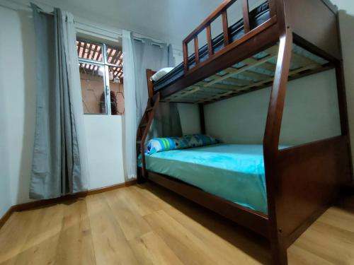 1 dormitorio con litera y suelo de madera en Elegante Suite ecualodge2, en Cuenca
