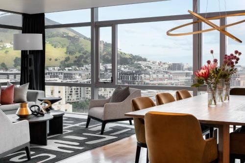 a living room with a table and chairs and a large window at The Westin Cape Town in Cape Town