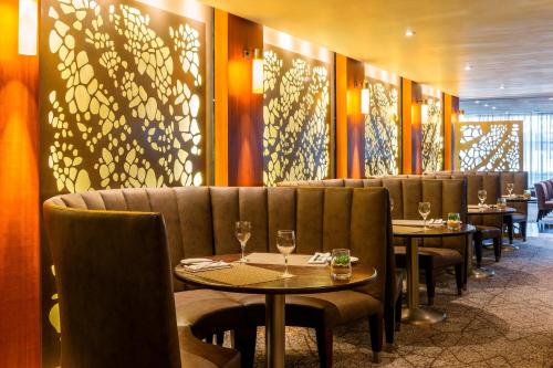a restaurant with tables and chairs with wine glasses at The Westin Cape Town in Cape Town