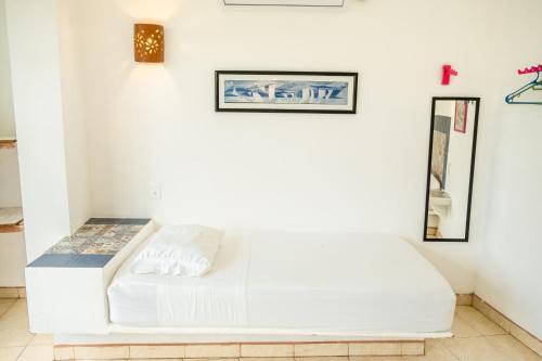 a white couch in a white room with paintings on the wall at Casa Mazunte Tierra Viva in Mazunte
