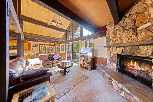 a living room with a large stone fireplace at Nightingale Retreat by Tahoe Getaways - 3BR, Close to Tahoe City, Walk to Bike Path & Private Beach Access in Tahoe City