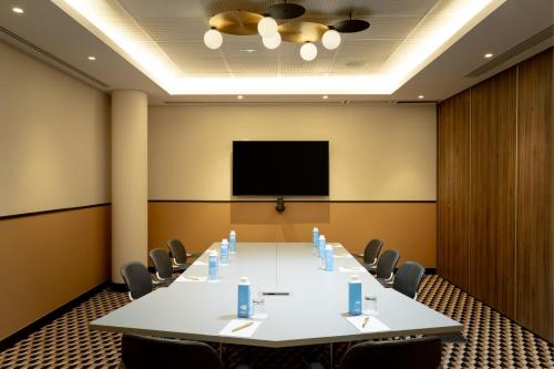a conference room with a large white table and chairs at Le Parchamp, a Tribute Portfolio Hotel, Paris Boulogne in Boulogne-Billancourt