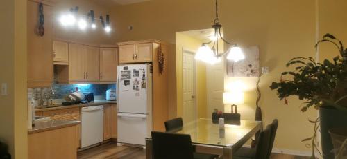 伊魁特的住宿－Grant Arctic Escape，厨房配有桌子和白色冰箱。