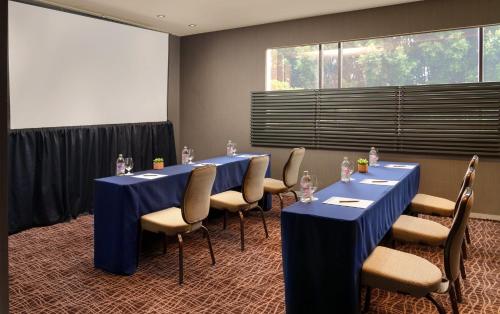 a conference room with blue tables and chairs and a window at Presidente InterContinental Mexico City by IHG in Mexico City
