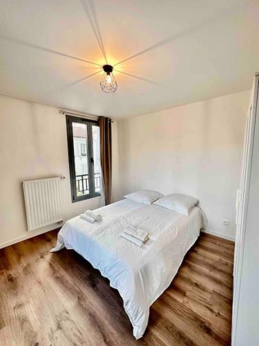 a bedroom with a large white bed with a ceiling at Magnificent apartment Paris Bagnolet 201 in Bagnolet