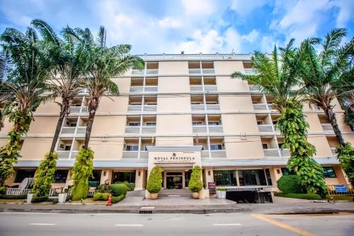 un hotel con palmeras frente a un edificio en Royal Peninsula Hotel Chiangmai, en Chiang Mai