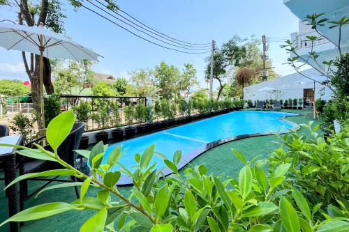 a swimming pool at a resort with an umbrella at Royal Peninsula Hotel Chiangmai in Chiang Mai