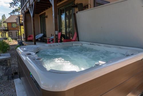 a hot tub on the side of a house at Truckee Luxe by Tahoe Getaways - 3 BR Luxury Gray's Crossing Townhome w Hot Tub on Golf Course - Close to Downtown & Northstar in Truckee