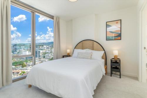 - une chambre avec un lit blanc et de grandes fenêtres dans l'établissement Sky Ala Moana 2908 condo, à Honolulu