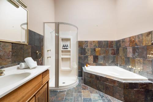 ein Badezimmer mit einer Badewanne und einem Waschbecken in der Unterkunft Sunset Lodge - Breathtaking Views in Orange