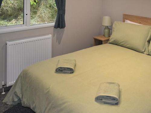 um quarto com uma cama com duas toalhas em The Finch em Dyke