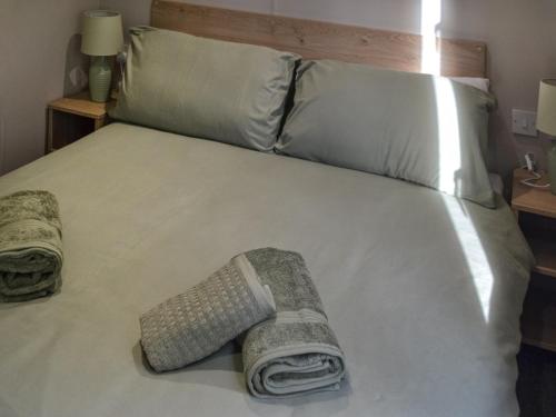 a bed with two towels and two pillows on it at The Falcon - Uk45538 in Dyke