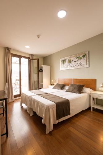 a bedroom with a large bed and a window at Gce Hoteles in Málaga