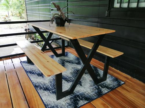 a wooden table and a bench on a rug at Casa Onca in Río Claro