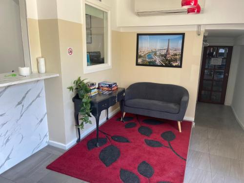 a living room with a chair and a red rug at St Kilda Accommodation in Melbourne