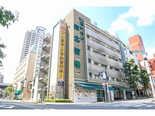 a large building on a city street with buildings at Hotel Continental Fuchu in Fuchu
