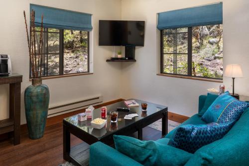 uma sala de estar com duas cadeiras azuis e uma mesa em Sheridan House Inn- Adult Only Accommodation em Williams