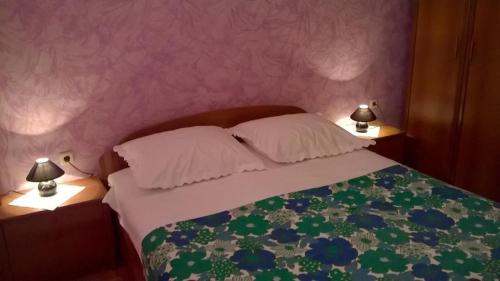 ein Schlafzimmer mit einem Bett mit zwei Lampen an Tischen in der Unterkunft Apartments by the sea Biograd na Moru, Biograd - 21597 in Biograd na Moru