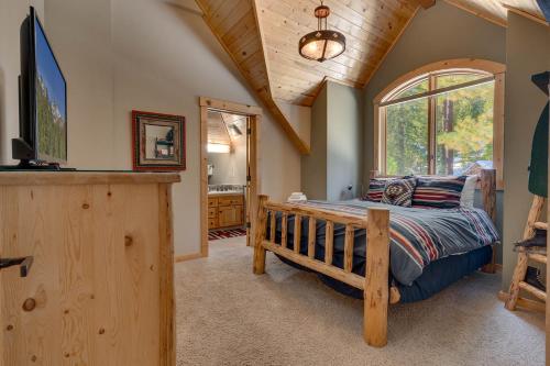 a bedroom with a bed and a large window at Tippy Canoe by Tahoe Getaways - 4BR West Shore w Private Hot Tub,, Sauna, EV & Walking Distance to Trailhead in Tahoma